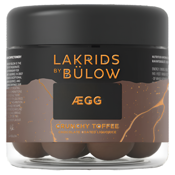 A clear jar of Lakrids by Bulow Crunchy Toffee features Danish chocolate-coated licorice (125g) in a gourmet treat, highlighted by a stylish black label with gold accents among Scandinavian confections.