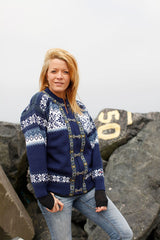 Navy blue wool cardigan with white Nordic snowflake patterns and decorative metal clasps.