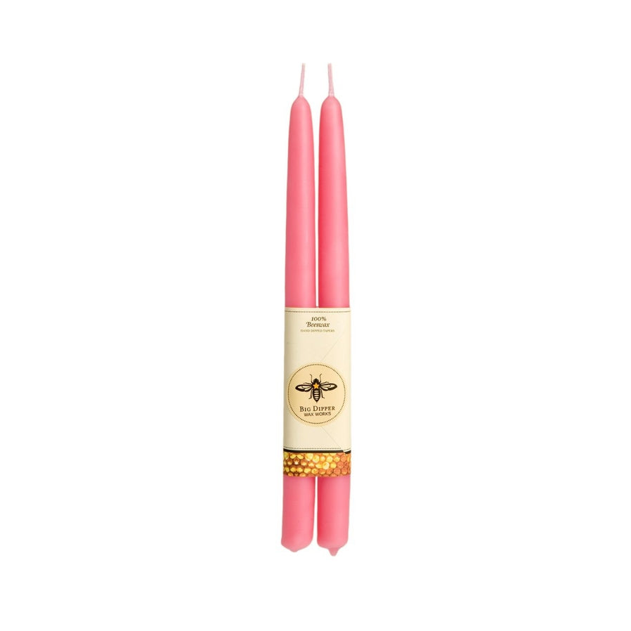 The Big Dipper Wax Works 100% Beeswax Taper Candle Pair showcases handcrafted pink tapers with a central bee-designed label, exuding elegance and artisanal beauty.