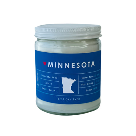 The Candle: Minnesota Candle – Fraser Fir Scent, Blue Label, Clear Jar is hand-poured with a soy coconut wax blend, features a heart and state outline label, is phthalate-free, and offers 50+ hours of burn time.