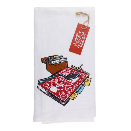 The Tea Towel - Guide Book Tea Towel Betty Crocker Recipes features a white Scandinavian design with a recipe box, spoon, and red patterned cookbook illustration. Finished with a red tag, it adds Nordic charm to any Minnesota kitchen.