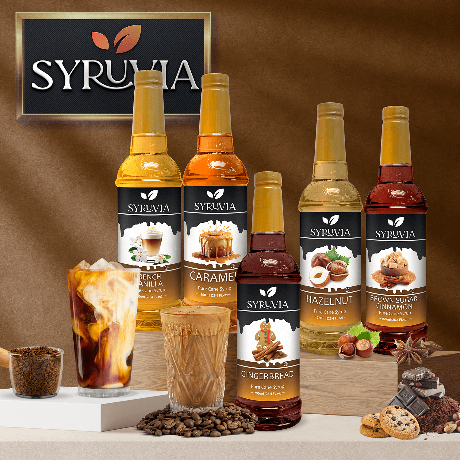 A bottle of Syrupia Pumpkin Spice Coffee Syrup, made with pure cane sugar, is displayed next to iced and hot coffee drinks and coffee beans.