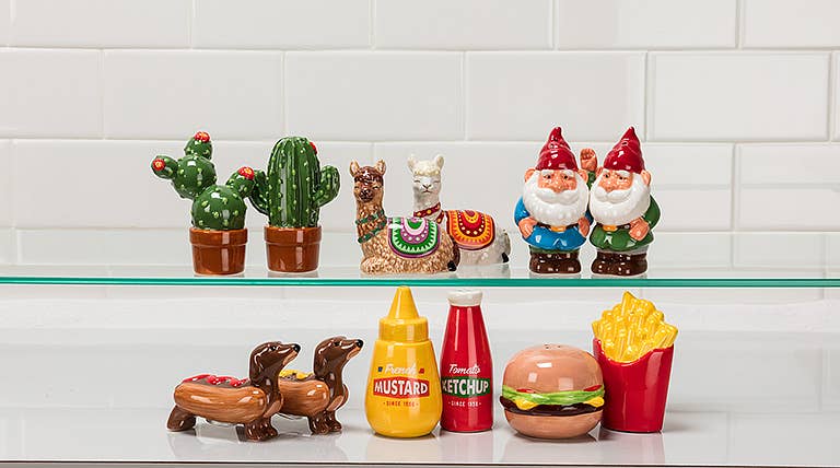 Garden gnome ceramic salt and pepper shakers, 3.5 inches tall, displayed on a glass shelf against a tiled wall.