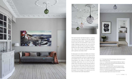A bright, elegant living room with natural light, white molding, pale wood floors, a gray sofa, wall art, and glass pendants. Next door, flowers on a console table echo the Scandinavian style in Scandinavian Home Interiors Inspired by Light by Niki Brantmark.