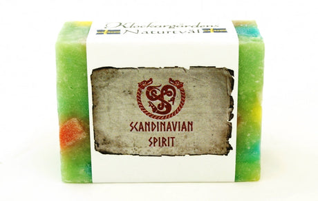 A rectangular bar of colorful organic soap, handmade in Sweden by Klockargardens, features a white label that reads "Scandinavian Spirit" with decorative red symbols on the front.