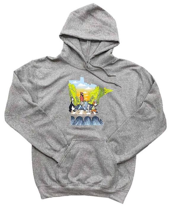 The MN Abbey Road 2022 Hoodie by Adam Turman features a vivid illustration of five people crossing stepping stones against a scenic backdrop of trees and mountains.