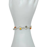 The Bracelet: Multi-Color Baltic Amber Sterling Silver Heart Bracelet, 8" long, featuring vibrant amber stones, is elegantly displayed on a mannequin hand.