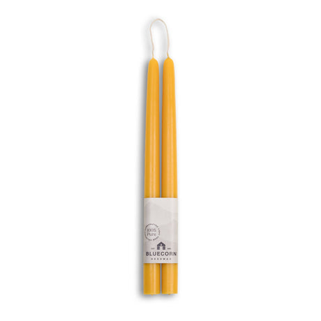 A pair of 10 yellow candles, handmade from eco-friendly beeswax, is packaged with Bluecorn Beeswax branding. These dripless tapers provide a clean and sustainable touch to any setting.