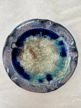The Candle Holder: Handmade Pottery and Recycled Glass Pillar & Ball Candle Holder, 5.75" diameter, features a textured center with blue, turquoise, and purple glaze on the edges, displayed on a light fabric surface.