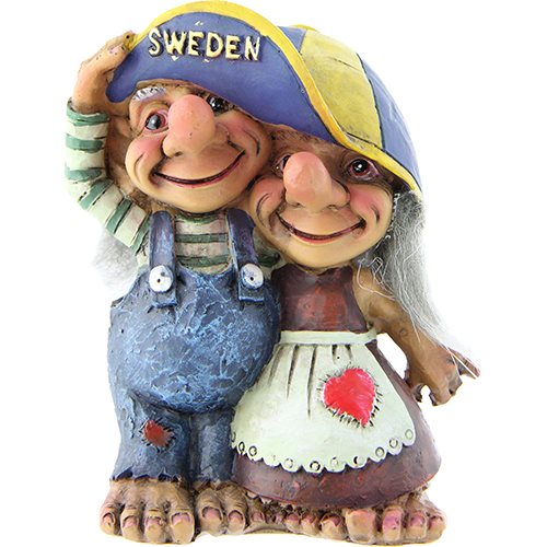 The "Troll: Troll Couple Under Swedish Cap" makes for an ideal Nordic souvenir, featuring two charming Swedish troll figurines. One troll is dressed in blue overalls, while the other wears a white apron with a heart design. Both are smiling and standing together in friendly companionship under a Sweden hat charm.