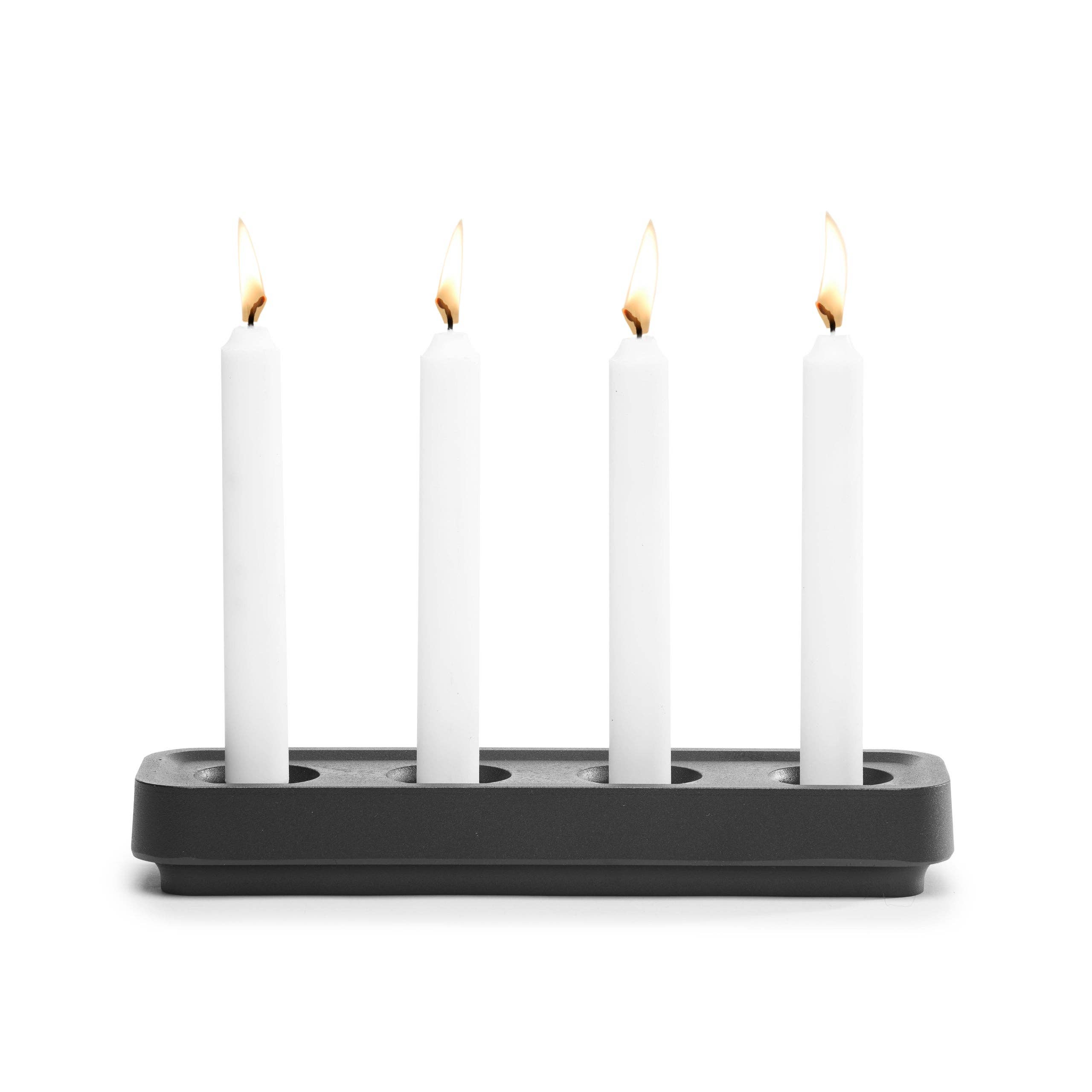 Four lit white candles gracefully stand in the sleek, eco-friendly Stumpastaken White Powdercoated Swedish Candle Holder, crafted from recycled aluminum and blending modern style with sustainability.