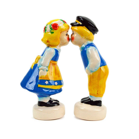 Two ceramic Swedish couple salt and pepper shakers with magnets, dressed in traditional European attire, face each other as if about to kiss—an enchanting Scandinavian gift.