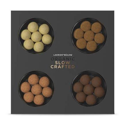 Box containing four round compartments of variously colored Candy: Lakrids by Bülow - Organic Slow Crafted (120g), offering an exclusive selection of flavors, all ethically produced.