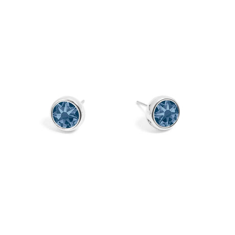 A pair of silver stud earrings, featuring denim blue Swarovski crystals from A&C Oslo, displayed on a white background.