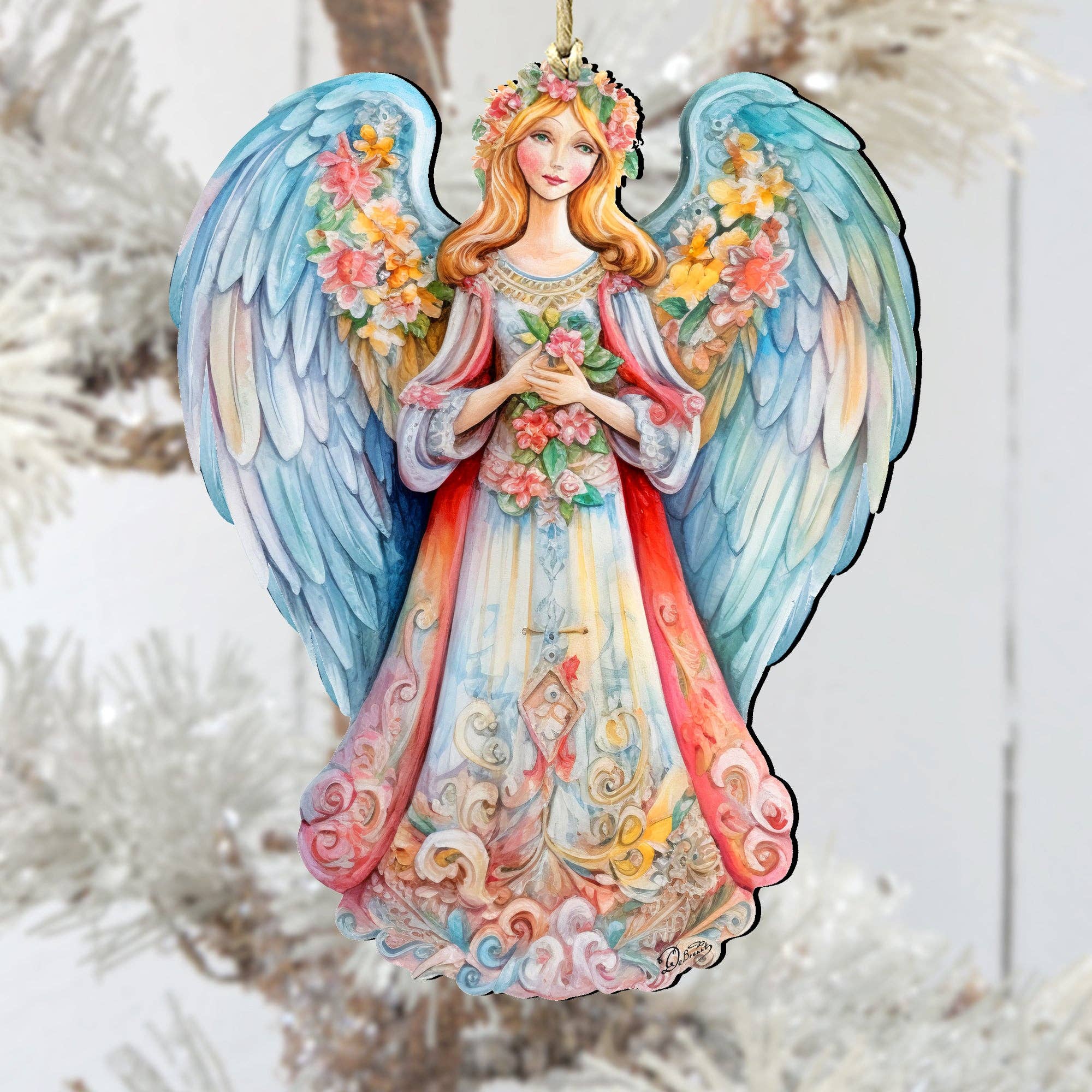 The Ornament: Angel Blue Floral Wooden Ornaments Debrekht Nativity Holiday features an angel with colorful wings and floral accents, dressed in a decorative gown and holding a heart with both hands. This handcrafted keepsake is sure to make a charming addition to any Nativity holiday décor.