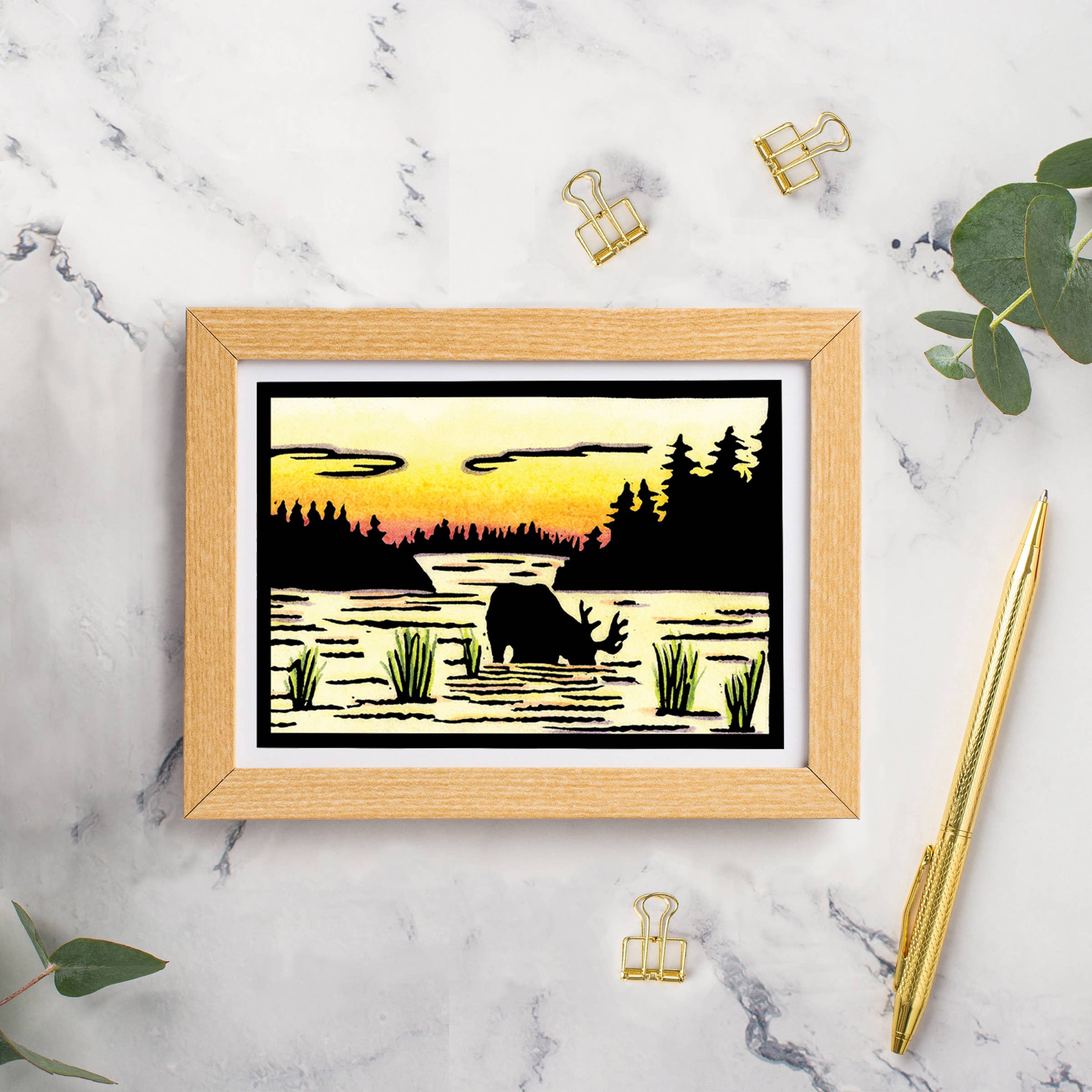 The Card: Evening Drink Moose by Sarah Angst is a 5x7 greeting card with envelope, blank inside, featuring moose artwork in a marsh at sunset—reminiscent of linocut art and made in America.