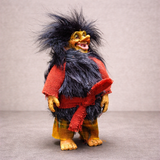 The Marketplace24 Troll: Borin Blackruff Troll Witch is an 8" handcrafted Scandinavian figurine with wild black hair, a red and black furry vest, red sash, plaid pants, yellowish skin, and a wide smile, displayed on a gray background.
