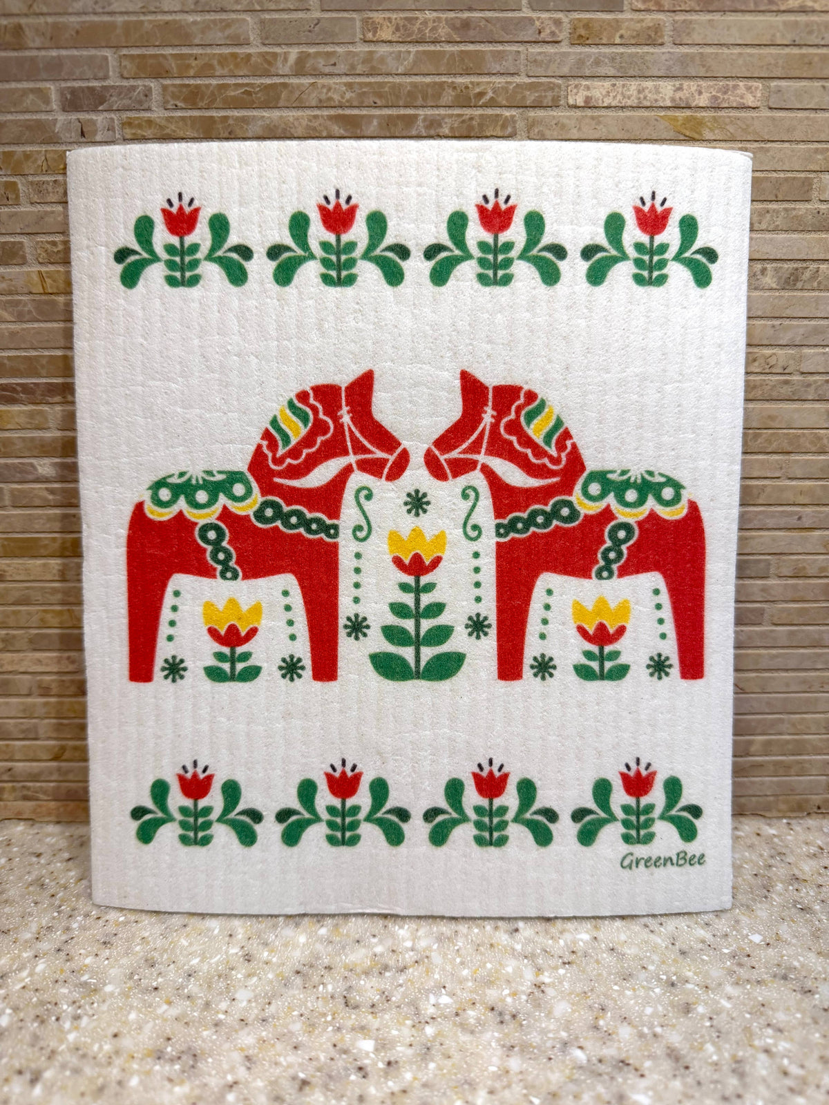 Swedish dishcloth with two red Dala horses surrounded by green and yellow floral rosemaling patterns.