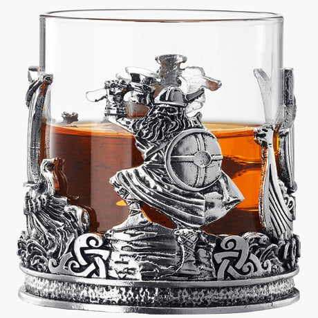 A glass of old fashioned liquor sits in a 12 oz Viking & Mythological Whiskey Drinking Glass, adorned with a warrior and intricate mythological design.