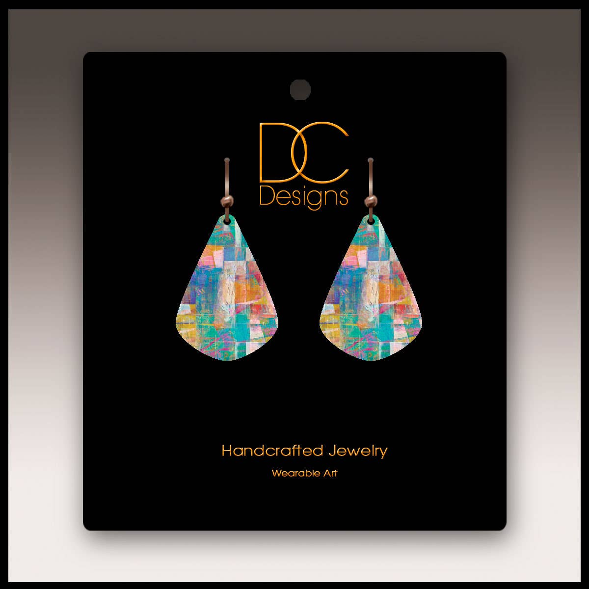 A pair of Mosaic Abstract Short Drop Handmade Earrings, teardrop-shaped, displayed on a black card labeled DC Designs Handcrafted Jewelry Wearable Art.
