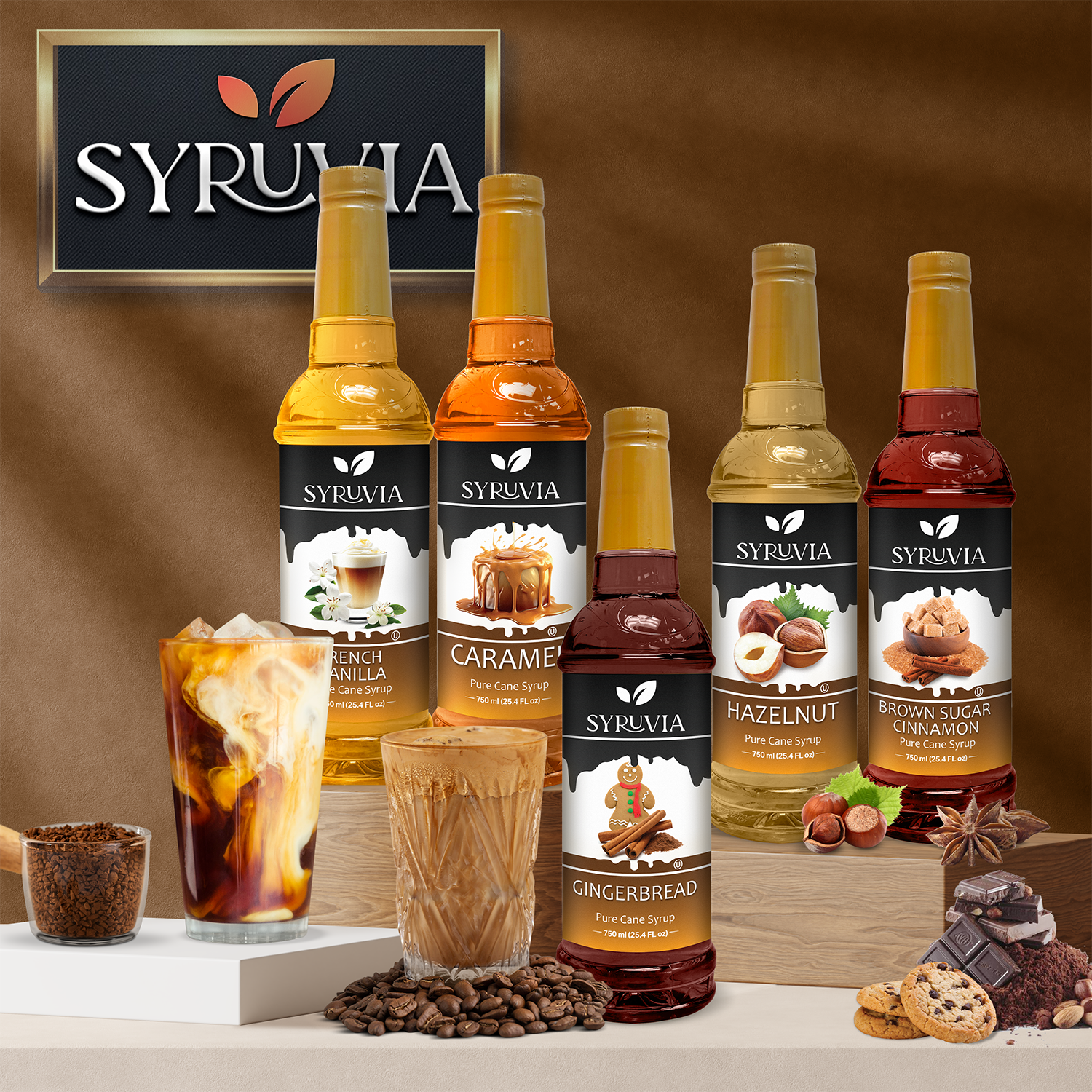 Five bottles of Syruvia Hazelnut Coffee Syrup with pure cane sugar are displayed on a countertop alongside iced and hot coffee, coffee beans, and flavor ingredients. All Syruvia syrups are gluten-free.