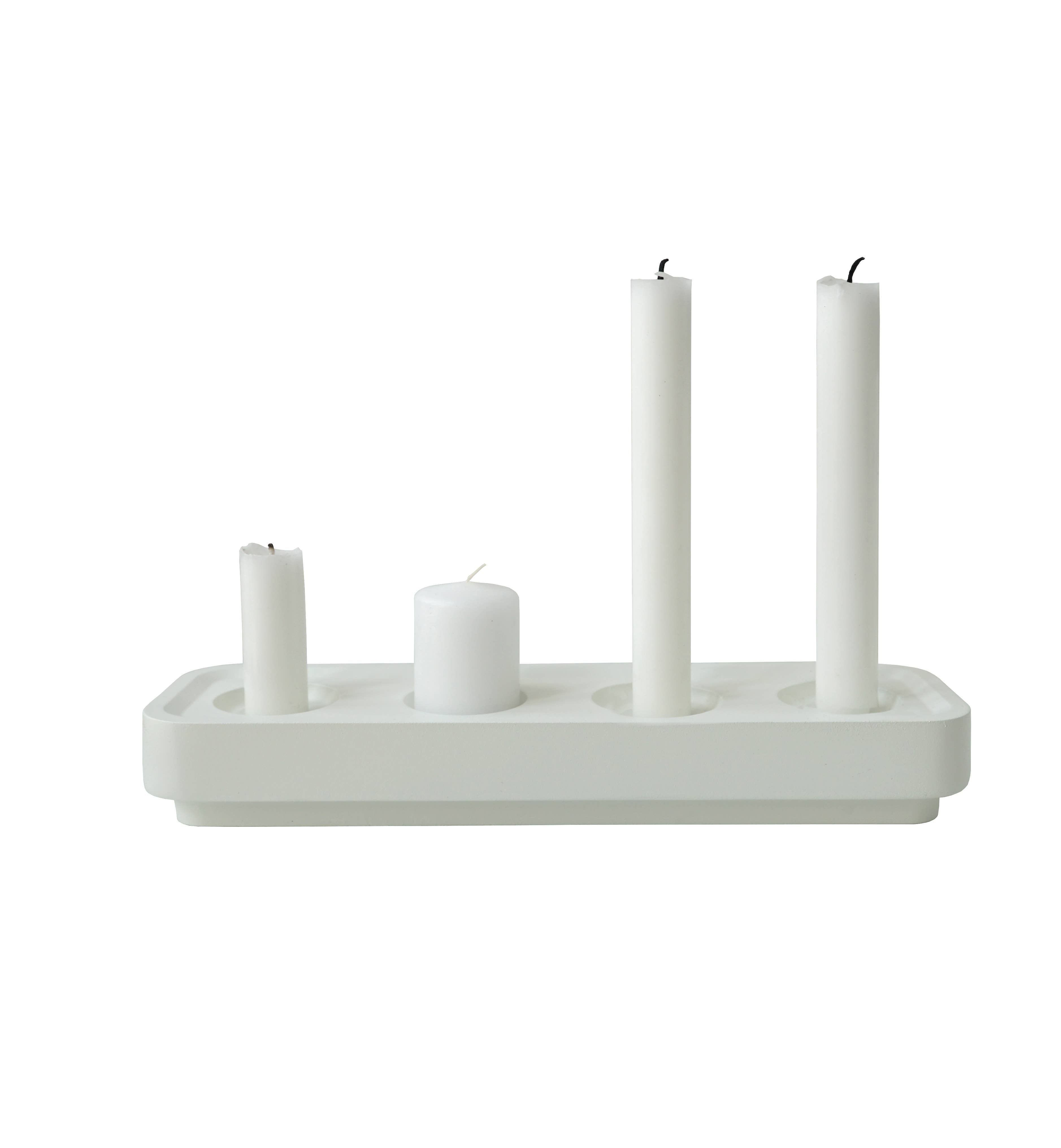 The Stumpastaken White Powdercoated Swedish Candle Holder, crafted from recycled aluminum, holds four white candles of different heights—two tall, one medium, and one short—combining elegance and eco-friendliness to add a serene glow to any space.