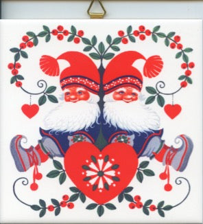 Two identical, festive Lapland Santas with red hats and beards sit back-to-back on the "Tile: Lapland Santas on Heart," surrounded by floral and heart motifs.