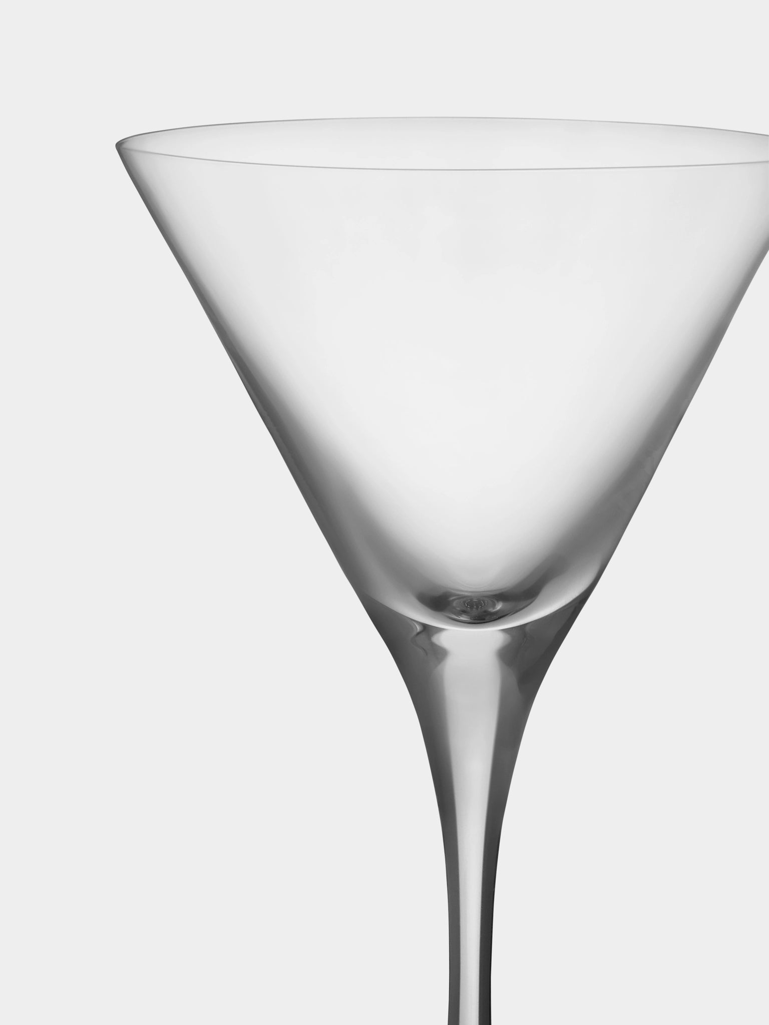 Close-up of an empty Orrefors: More Martini Glass 6.4oz (2-Pack) against a plain white background. The crystal glass features a smooth, elegant shape with a tall stem, epitomizing sophisticated simplicity.