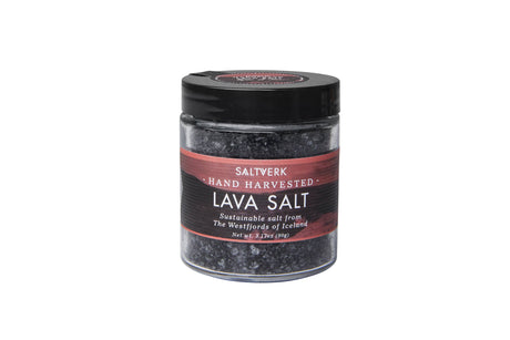 A clear glass jar from the SALTVERK Gift Set, labeled with one of four Icelandic salts—Flaky Sea Salt, Lava Salt, Birch Smoked Salt, or Arctic Thyme Salt—each hand harvested in the Westfjords and topped with a black screw lid.