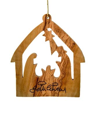 The Stable with Nativity ornament is made from Olive Wood and includes cut-out figures of Mary, Joseph, and baby Jesus. It features a star and the word Bethlehem etched at the bottom, capturing the essence of the Holy Land.