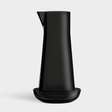 The Orrefors: Carafe with Bowl features a tall, black carafe designed by Björn Dahlström, paired with a matching shallow bowl and photographed against a plain light background.