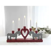 The Star Trading Leksand Electric Candelabra with 5 lights creates a cozy atmosphere, featuring two horse figures and a heart in the center, all set against a light background.