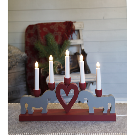 The "Leksand Candlestick" by Star Trading features five LED candle sticks with two gray Swedish Dala Horses and a red heart, creating a charming wooden candelabra centerpiece.