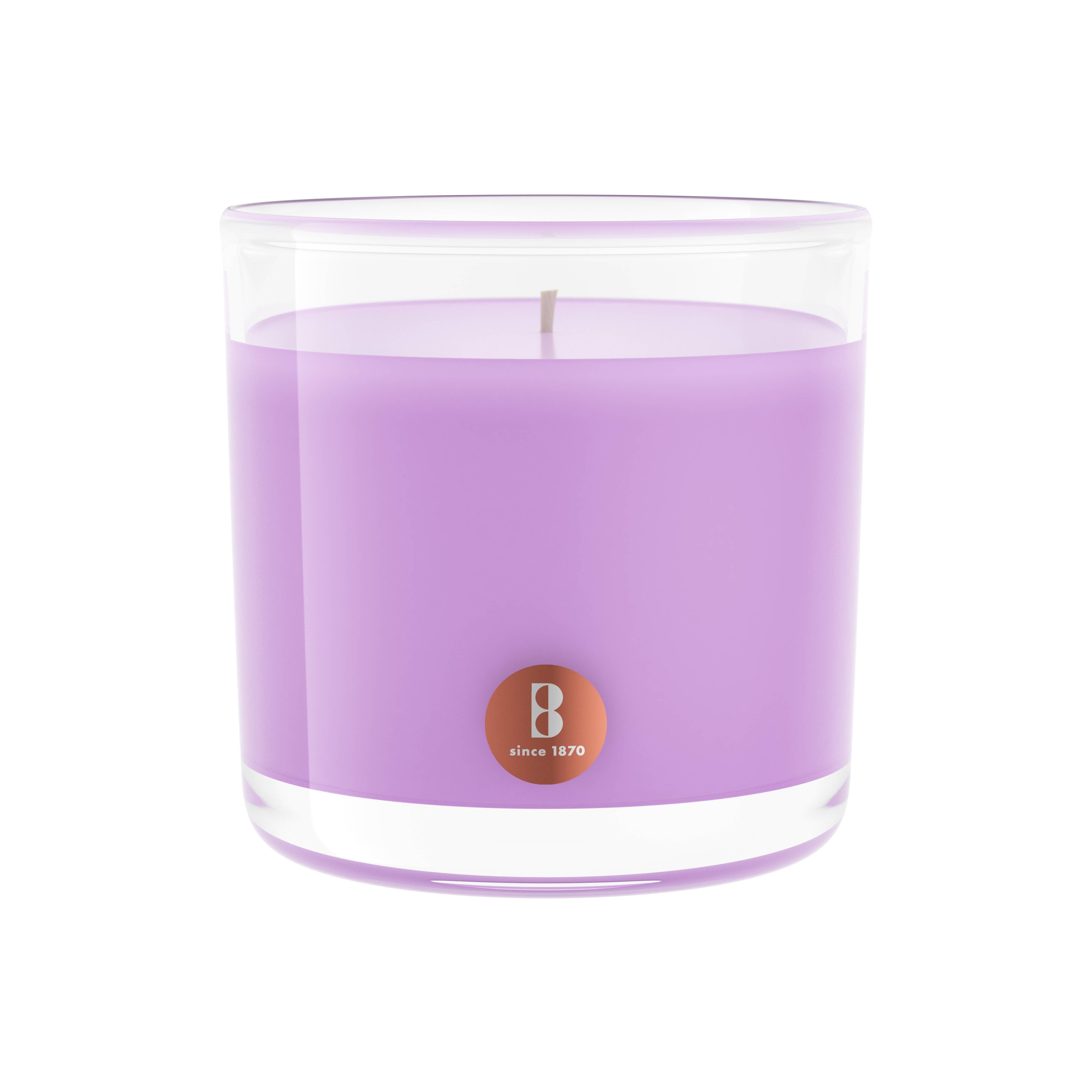 A lavender-scented candle in a clear glass jar, featuring a small label that reads "since 1870," is crafted using high-quality natural extracts.