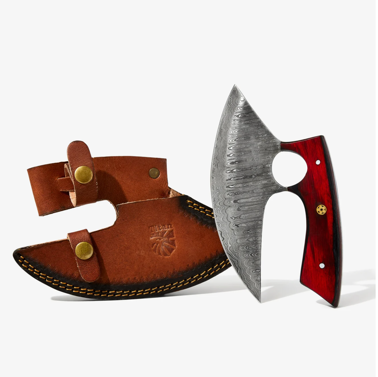 The Alaskan Ulu Style Knife features a handmade Damascus steel blade and a red & black diamond wood handle, standing upright beside its brown leather sheath with brass buttons and stitching.