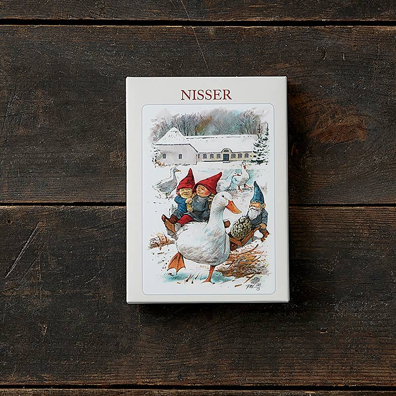 Product box labeled “Nisser” featuring three gnome-like children in red hats riding a goose, styled after traditional Scandinavian holiday art.