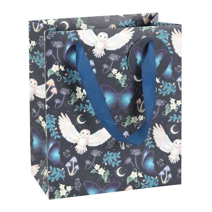 Gift Bag: Midnight Forest Owl Print Medium Gift Bag features a dark background with an owl print, blue butterflies, flowers, leaves, crescent moons, and blue fabric handles—a magical way to present your gifts.