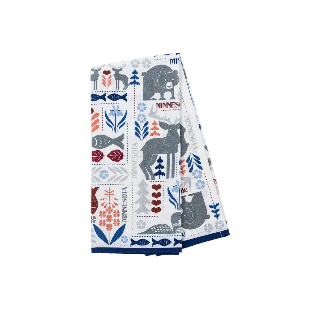 The Tea Towel: Minnesota Nordic Adventure is a folded white towel decorated with colorful illustrations of Minnesota-themed motifs like animals, trees, fish, hearts, and "Minnesota.