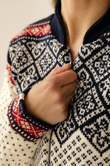 Cardigan in navy blue, red, and cream with Norwegian geometric motifs and a fleece-lined collar.