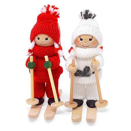 The 5" tall Scandinavian Girl on Skis figurine features a handcrafted wooden design with a red knit outfit, ski poles, and wooden skis—a charming Nordic decoration for any space.