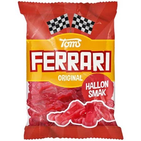 The package of Toms - Sweet Raspberry Ferrari candy, made in Denmark, features a chewy interior with a raspberry taste and is adorned with racing flags on the design.