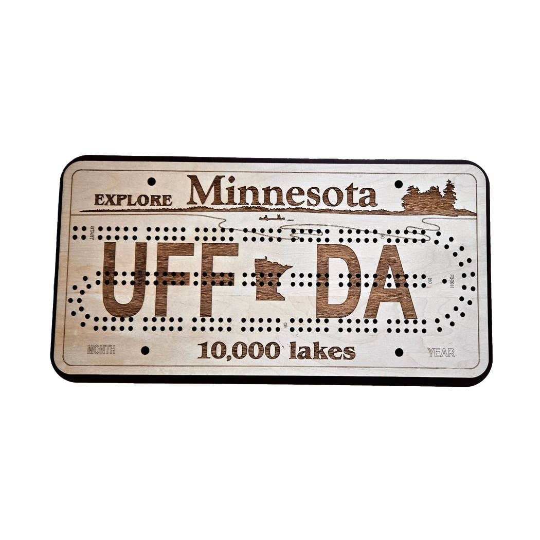 The Gme: UFF DA Explore Minnesota 10,000 Lakes License Plate Cribbage Board is a handcrafted board shaped like a Minnesota license plate, engraved with UFF DA, Explore Minnesota, and 10,000 lakes.