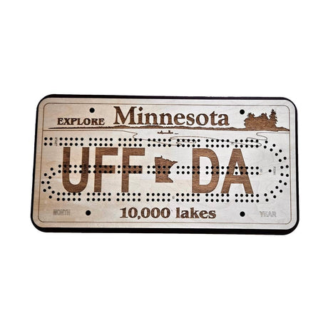 The Gme: UFF DA Explore Minnesota 10,000 Lakes License Plate Cribbage Board is a handcrafted board shaped like a Minnesota license plate, engraved with UFF DA, Explore Minnesota, and 10,000 lakes.