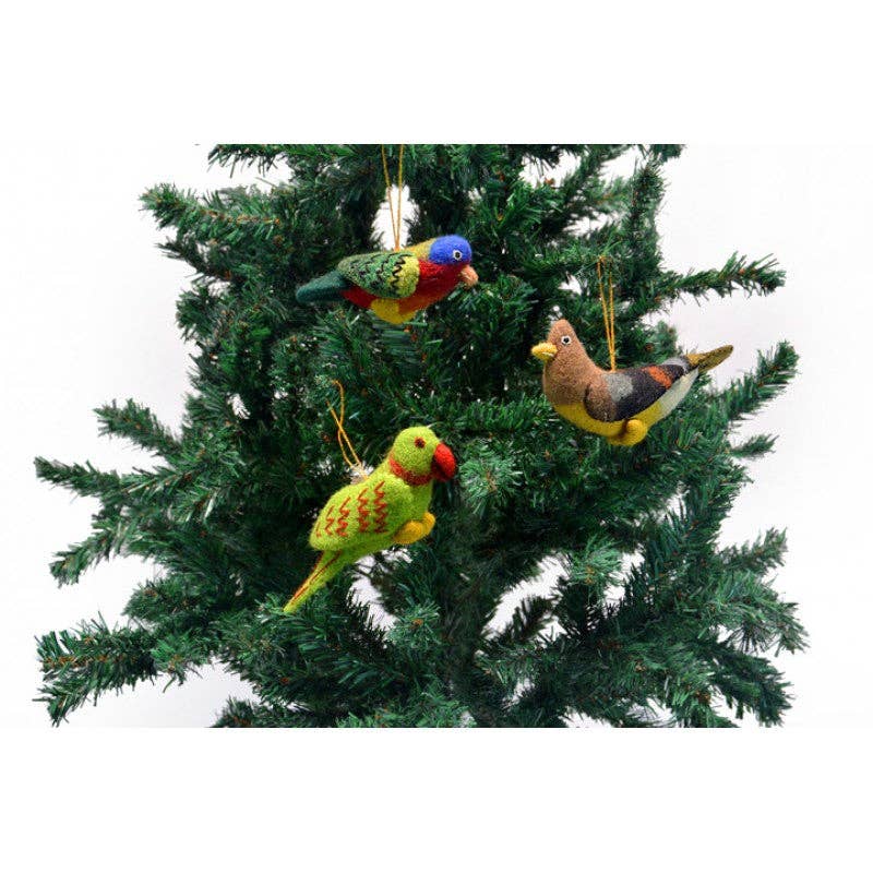 Three grey and white felt bird ornaments, crafted from 100% wool, elegantly hang as decorations on a green Christmas tree.