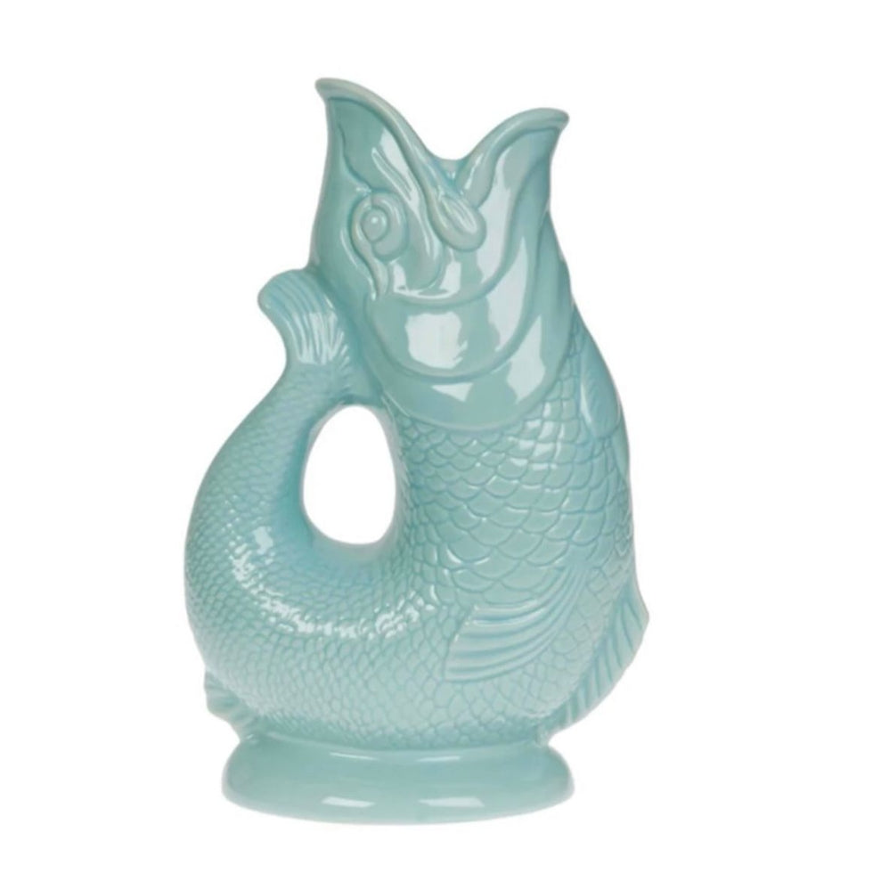 The Gluggle Jug: Eau De Nil, a teal ceramic vessel in the shape of an upright fish with its mouth open, features a unique and beloved quirky design that American consumers adore for their dinner tables.