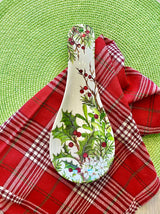 The Spoon Rest: Holly & Berries Christmas Holiday sits on a red plaid cloth over a green woven placemat, bringing festive cheer and seasonal style to your eco-friendly dinnerware collection.