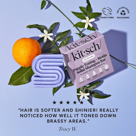 A Kitsch Hair Purple Toning Shampoo & Conditioner Bar Combo for color-treated and grey hair (2 x 2.7 oz bars), shown with oranges, white flowers, green leaves on lavender, includes customer reviews and product benefits.