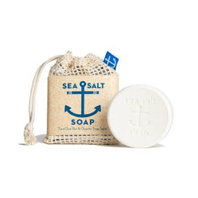The Swedish Dream Sea Salt Soap Travel Size Bar, accompanied by a soap saver made from organic cotton mesh, features a blue anchor design and serves as a gentle exfoliator for revitalized skin.