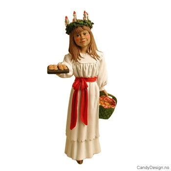 The Figurine: St Lucia with Cardamon Buns by Carl Larsson artfully portrays a girl in a white dress adorned with a red sash and wearing a candle crown. She carries a basket and presents cookies on a tray, embodying the spirit of festive warmth.