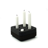 The Stumpastaken Fyran Four Candle Holder is a square, white powder-coated piece made from 100% recycled aluminum. Its classic Swedish design holds four candles of varying heights for timeless, sustainable interior decor.